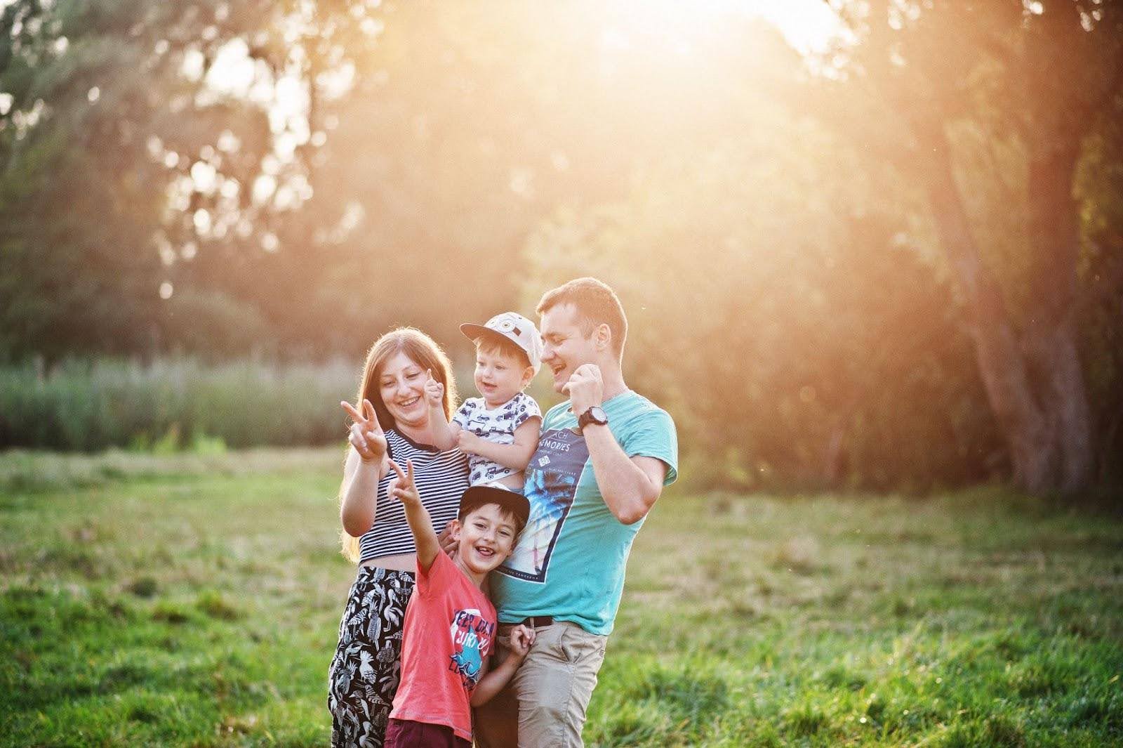 A family is posing for a photo in a field during their Family Services session.